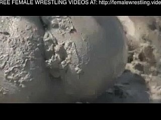 Girls wrestling in along to mud
